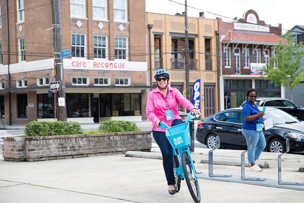 This is a picture of a woman riding a Blue Bike in New Orleans.