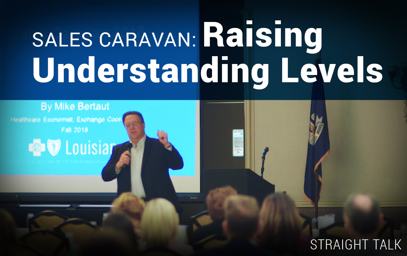 This is a photo of Mike Bertaut speaking at a seminar with text on the photo that reads: "Sales Caravan: Raising Understanding Levels."